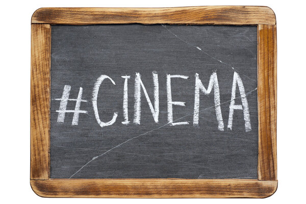 Cinema hashtag handwritten on vintage school slate board isolated on whit