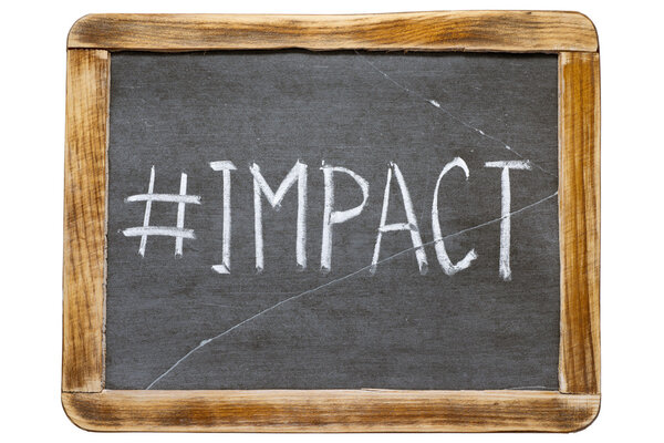 Impact hashtag handwritten on vintage school slate board isolated on white