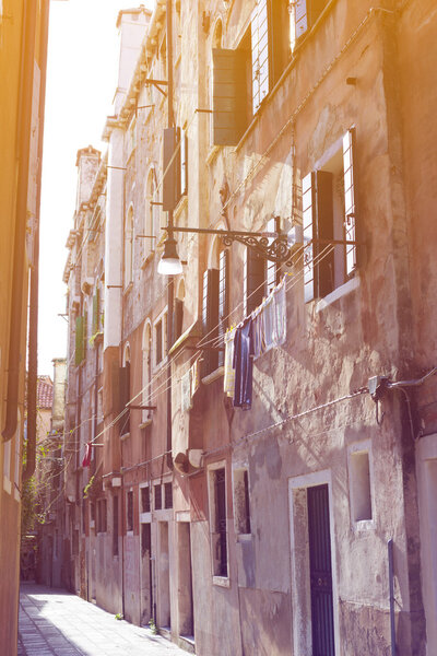 Narrow street in Venice by bright sunny day toned image