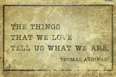 The things that we love tell us what we are - quote of ancient Italian priest, theologian and philosopher Thomas Aquinas printed on grunge cardboard clipart