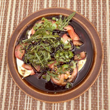 Mozzarella mit Tomate, Rucola und Basilikum in Balsamicodressing