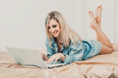 sarışın kadın yatakta laptop ile çalışma