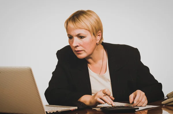 Volwassen zakenvrouw volwassen zakenvrouw met behulp van een rekenmachine op — Stockfoto