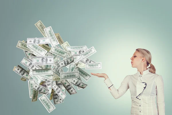 Business woman blowing a bunch of dollars — Stock Photo, Image