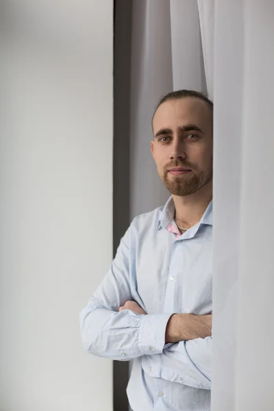 Hanfsome man in de buurt van het venster — Stockfoto