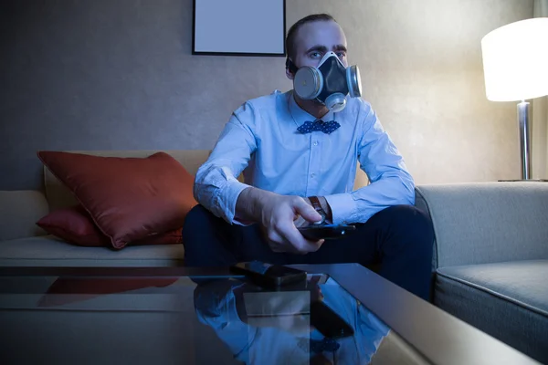 Man in gasmasker Tv kijken — Stockfoto