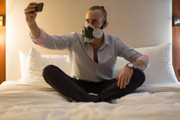 Man in het masker op het bed — Stockfoto