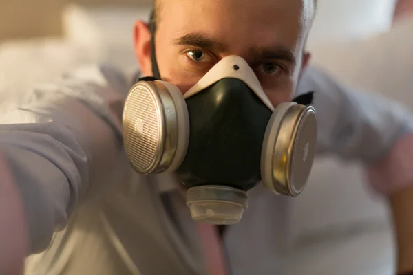 Man in het masker op het bed — Stockfoto