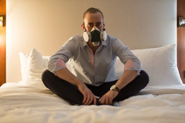 Man in het masker op het bed — Stockfoto