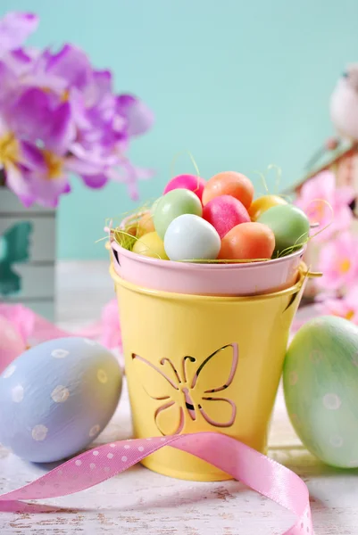 Påsk pastellfärger dekoration med godis ägg i lilla hink — Stockfoto