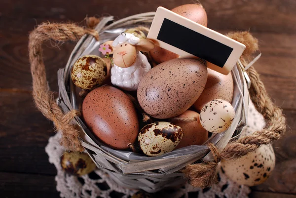 Easter eggs and decoration in old basket — Stock Photo, Image