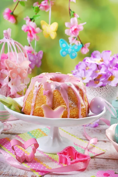 Osterringkuchen mit rosa Zuckerguss und schmetterlingsförmigem Zuckerspri — Stockfoto