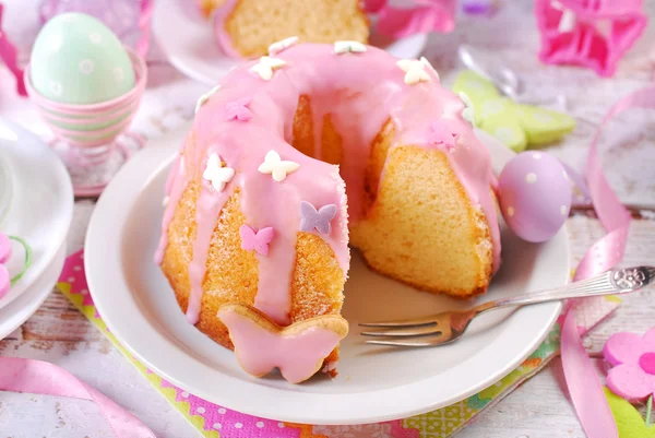 Osterringkuchen mit rosa Zuckerguss und schmetterlingsförmigem Zuckerspri — Stockfoto