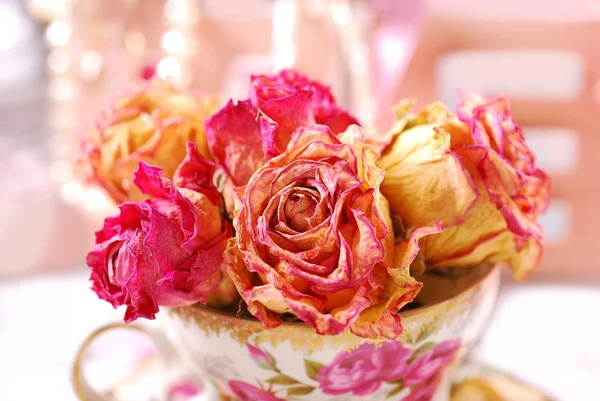 Красивые сушеные розы в фарфоровой чашке — стоковое фото