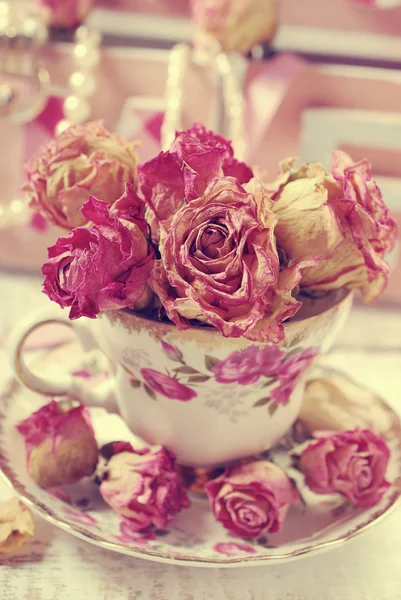 ดอกกุหลาบแห้งที่สวยงามในถ้วยชาพอร์ซเลน — ภาพถ่ายสต็อก