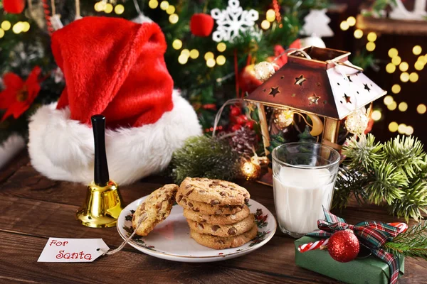 圣诞期间 圣诞老公公在木制桌子上放了一杯牛奶和饼干 图库照片