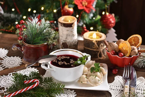 ポーランドの伝統的なクリスマスイブ赤いボルシチとお祝いのテーブルの上にサワークラウトとキノコの充填餃子 — ストック写真