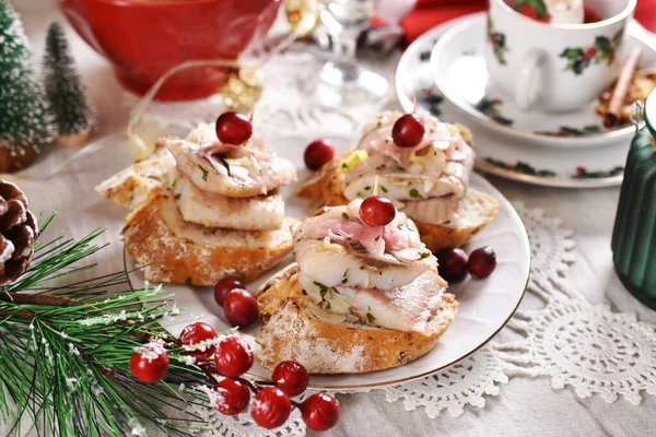 お祝いのテーブルの上でニシンと生姜と玉ねぎを油に漬けクリスマス用のミニカナッペ — ストック写真