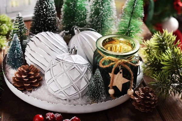 白い装飾が施されたクリスマス装飾 緑のガラス瓶のキャンドル 雪のある丸いトレイのミニチュアクリスマスツリー — ストック写真