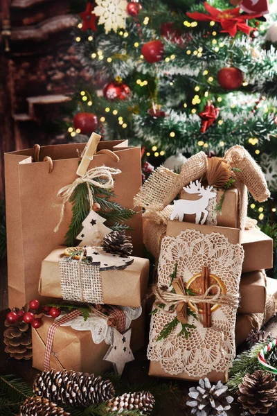 Diy クリスマスツリーの前に素朴なスタイルでレース ロープや装飾品で創造的に包まれたクリスマスプレゼント — ストック写真