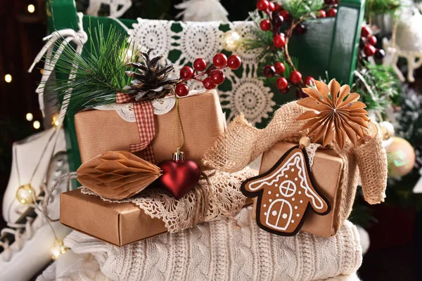 圣诞宁静的生活 在圣诞树前的绿椅上挂着一堆羊毛衫和手工纸包着礼物 — 图库照片