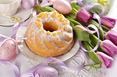 Mor laleli Paskalya pastası ve beyaz arka planda yumurta süslemesi.