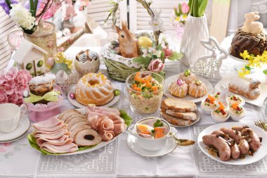 Polonya 'daki şenlik masasında geleneksel paskalya yemekleri, sosis, yumurta, salata ve kek.