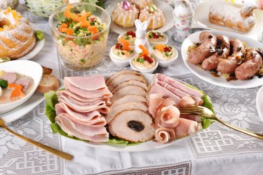 Geleneksel Paskalya yemekleri Polonya 'daki şenlik masasında pişmiş et, kızarmış sosis, yumurta, salata ve kek tabakları.