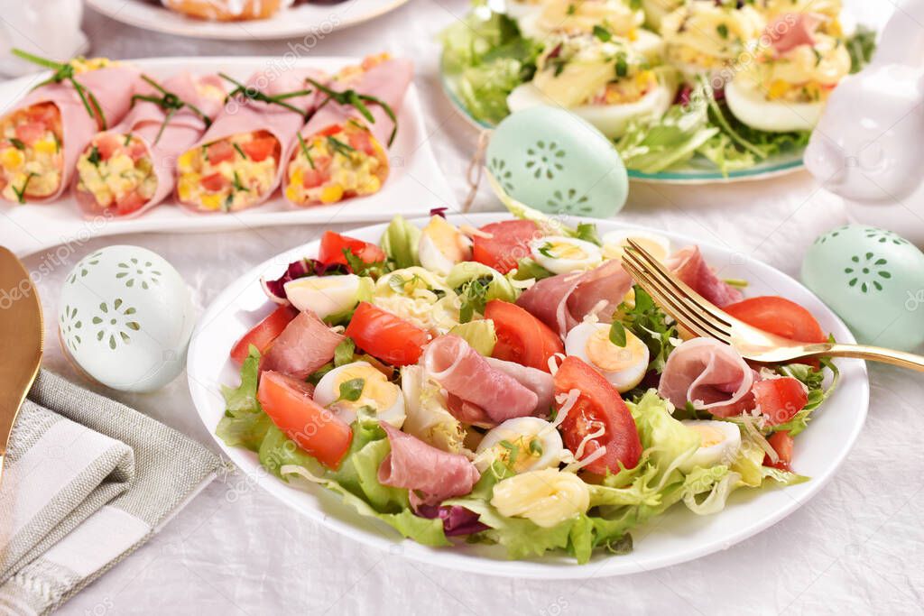 Fresh salad with quail eggs, prosciutto ham, tomato, lettuce mix and mayonnaise for Easter breakfast