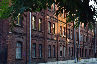 Lodz 'da günbatımında eski kırmızı tuğla bina heykeli