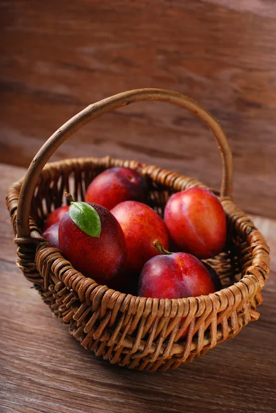 Fresh plums in a wicker basket — Stock Photo, Image