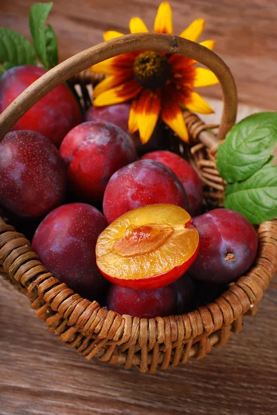 Fresh plums in a wicker basket — Stock Photo, Image