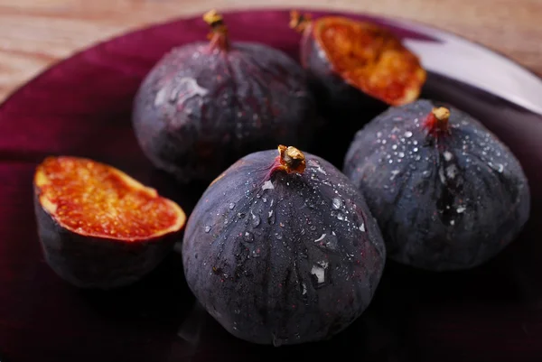 Fresh figs on purple plate — Stock Photo, Image