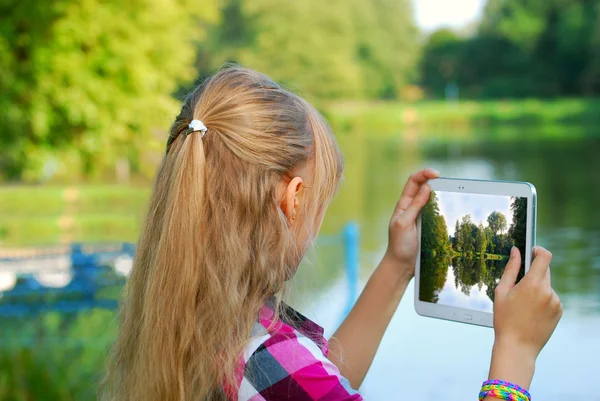 Young girl taking photo of the lake by tablet pc — Stock Photo, Image