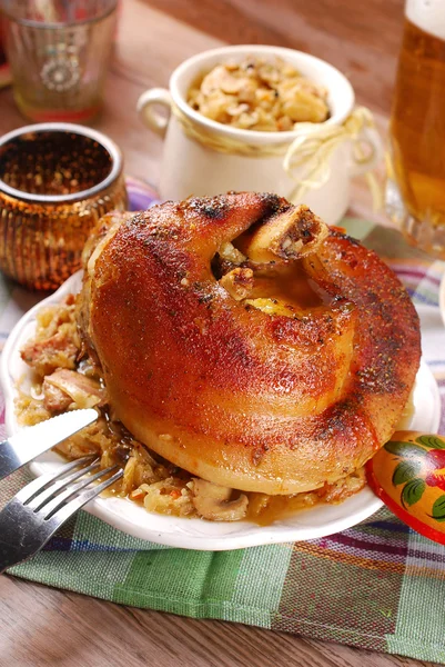 Roasted in beer pork knuckle with sauerkraut for dinner — Stock Photo, Image