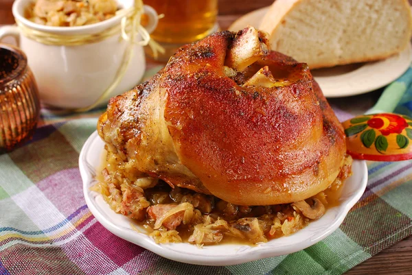 Roasted in beer pork knuckle with sauerkraut for dinner — Stock Image Roasted in beer pork knuckle with sauerkraut for dinner Stock Picture