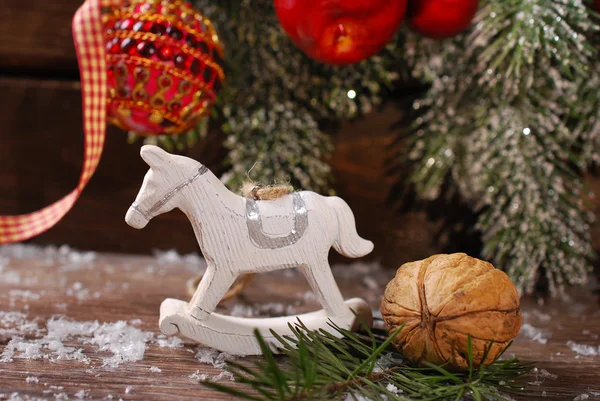 Christmas decoration with rocking horse toy on wooden backgroun — Stock Photo, Image
