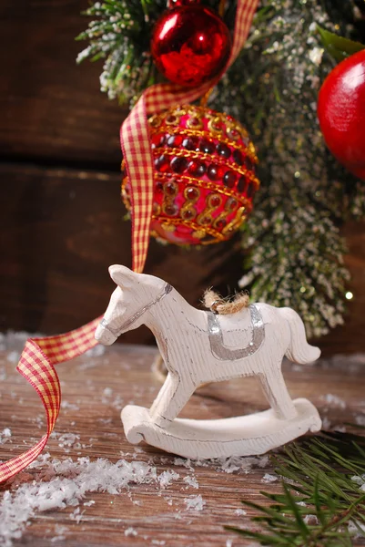 Christmas decoration with rocking horse toy on wooden background — Stock Photo, Image