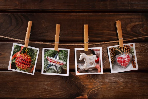 Fotos de Navidad colgando de la cuerda contra el fondo de madera — Foto de Stock