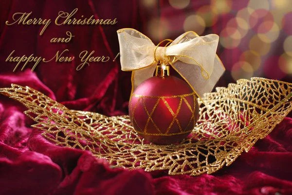 Natal carmesim bugiganga no ornamento com aberturas folha dourada — Fotografia de Stock