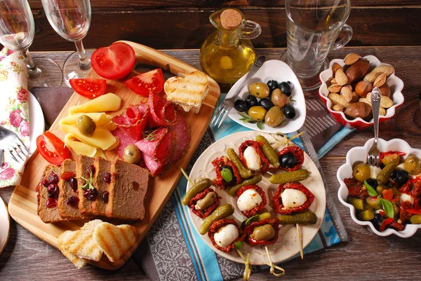 Appetizers and antipasti on wooden table — Stock Photo, Image