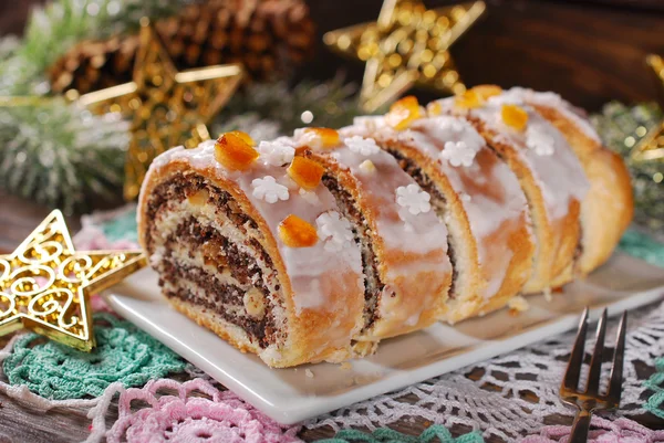 Нарезанный рождественский маковый торт с глазурью и снежинкой — стоковое фото