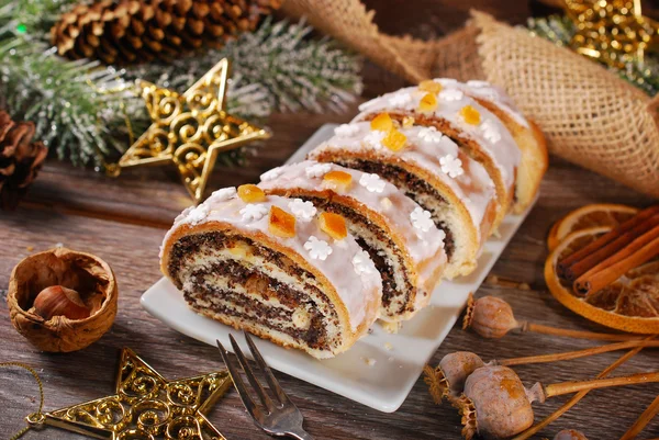 Gesneden kerst papaver zaad cake met slagroom en sneeuwvlok sprink — Stockfoto