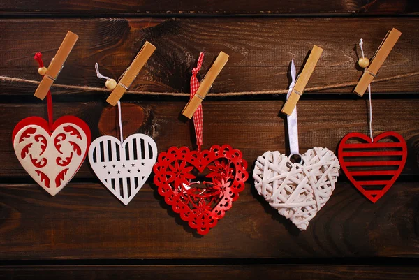 Valentine hearts hanging on wooden background — Stock Photo, Image