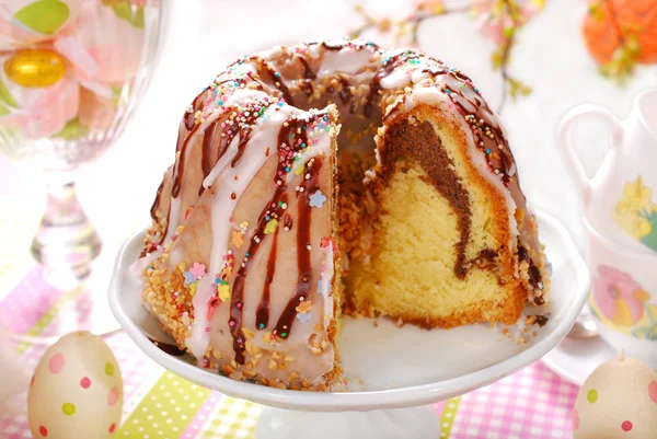 Ring cake with icing and chocolate glaze on easter table — Stock Photo, Image