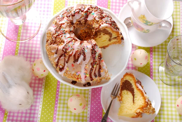 Ring cake with icing and chocolate glaze on easter table — Stock Photo, Image
