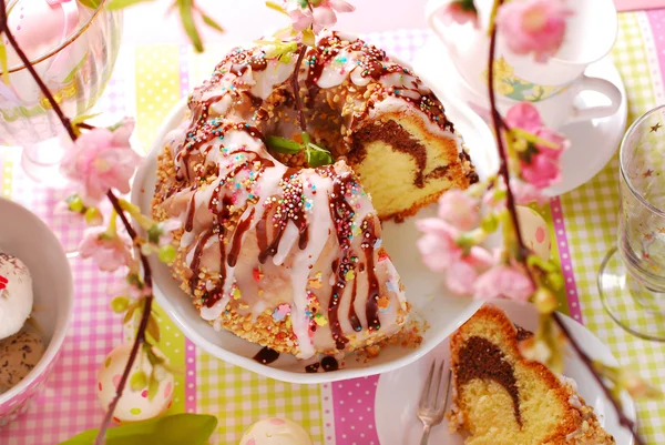 Torta anello con glassa di cioccolato e glassa di glassa sul tavolo pasquale — Foto Stock