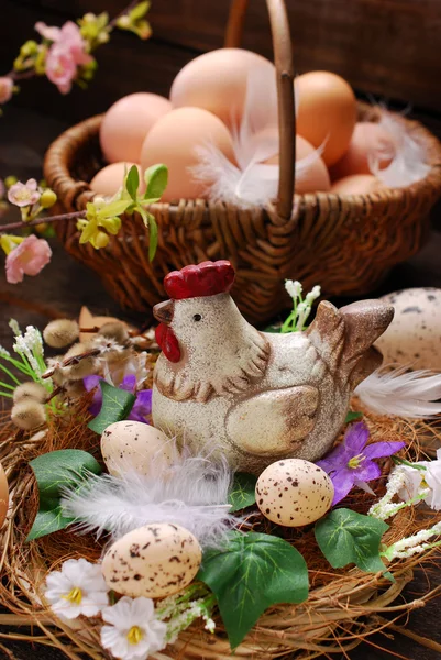 Easter decoration of hen in the nest and wicker basket with eggs — Stock Photo, Image