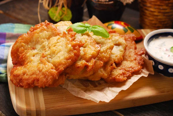 Potato cakes lying on wooden board with bowl of  vegetable and m — Stock Photo, Image