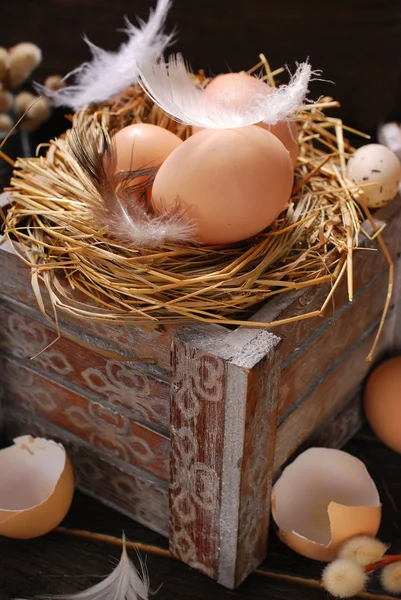 Rustieke Stilleven met eieren in nest op houten kist voor Pasen — Stockfoto